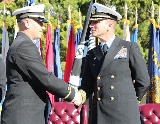 Ensign Tariq Jaber, left, shakes hands with Capt. Peter Maculan, commanding officer of Center for Seabees and Facilities Engineering and the Naval Civil Engineer Corps Officers School (CECOS), during a graduation ceremony.  Jaber was one of 33 U.S. Navy Civil Engineer Corps (CEC) students who completed the 15-week-long CEC Basic Qualification Course at CECOS.