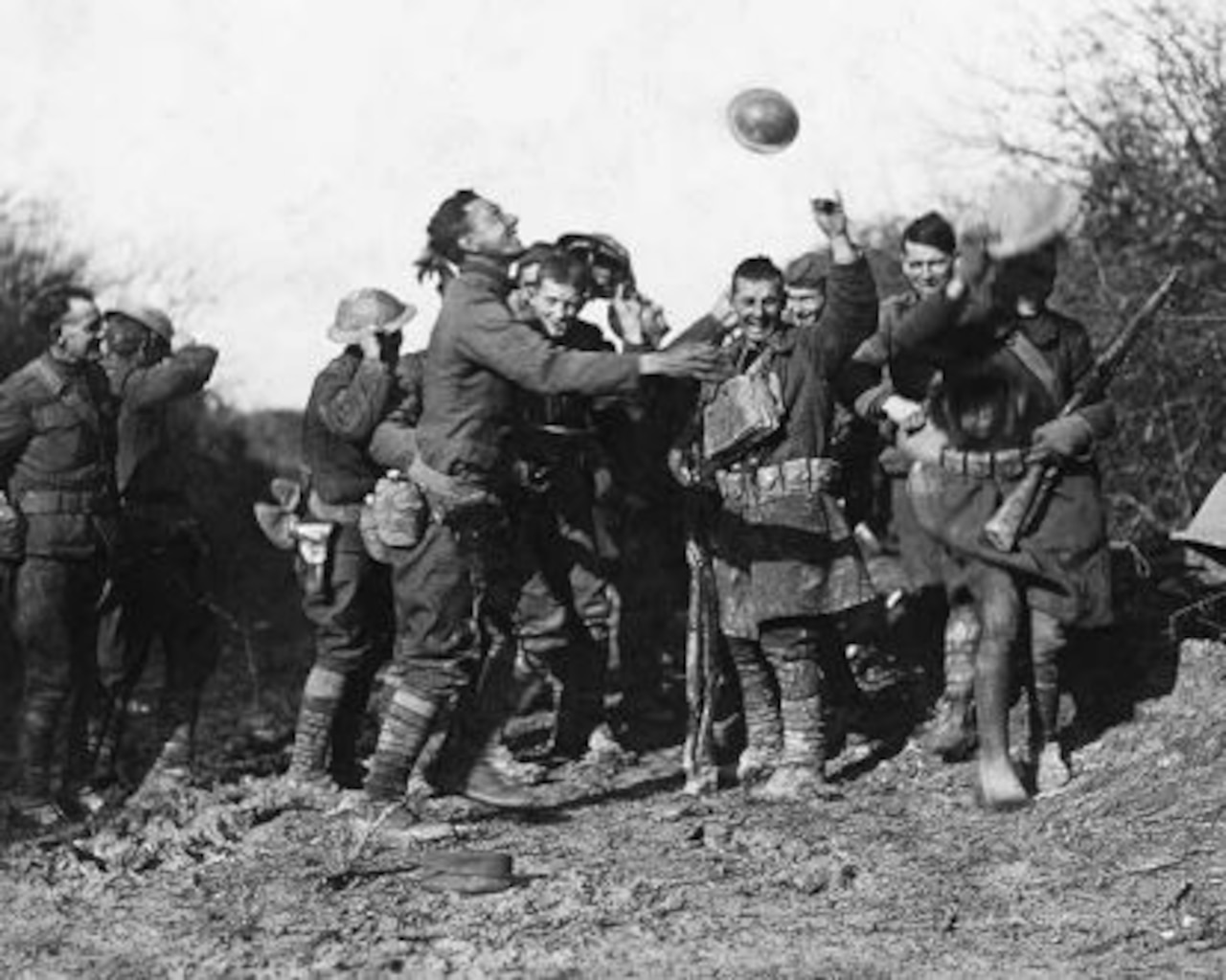 Soldiers throw up their arms and caps in delight.