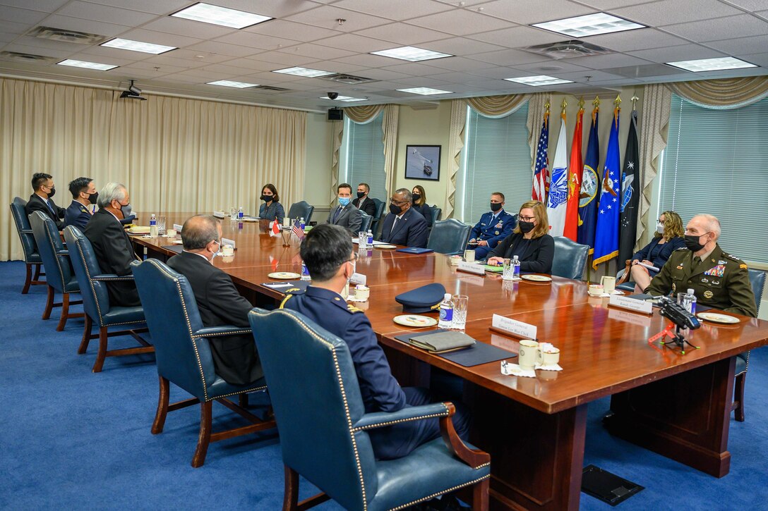 Officials meet at a long table.
