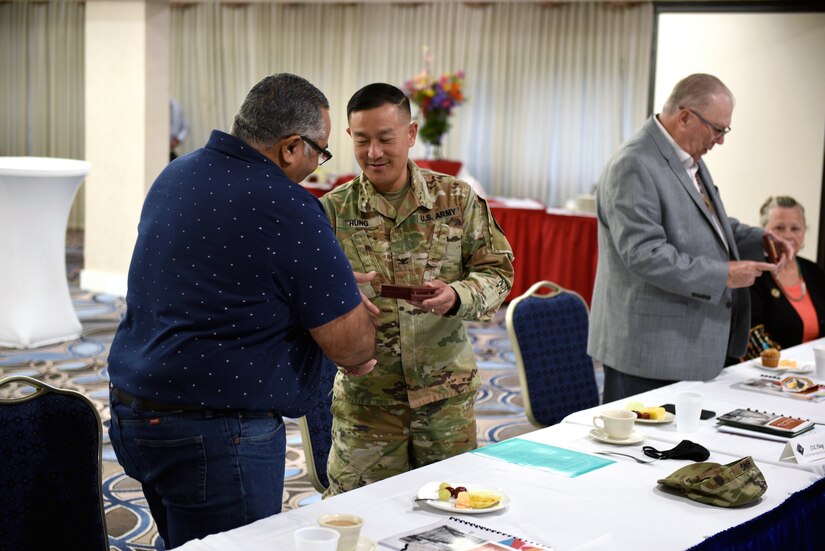 U.S. Army Col. Harry D. Hung, Joint Base Langley-Eustis vice commander, presents Mr. Dana Adkins, Chickahominy Indian Tribe environmental office director, with a welcoming gift at the beginning of the annual Tribal Consultation held at Joint Base Langley-Eustis, Virginia.