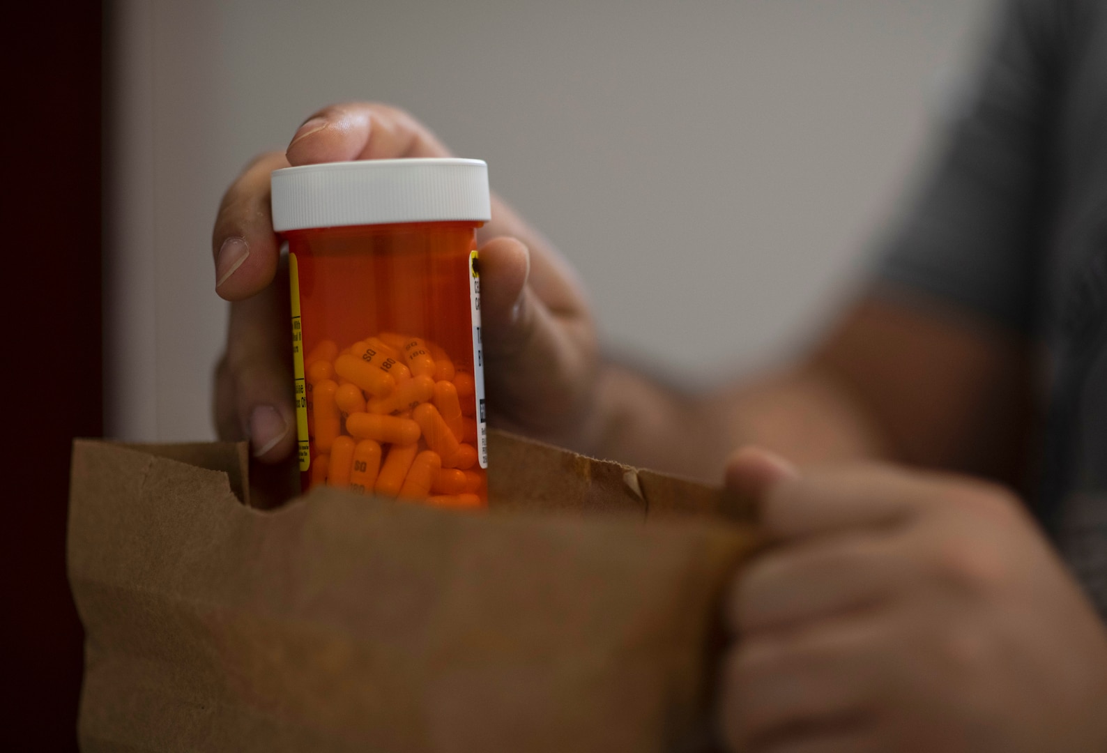 A person examines a prescription medicine bottle