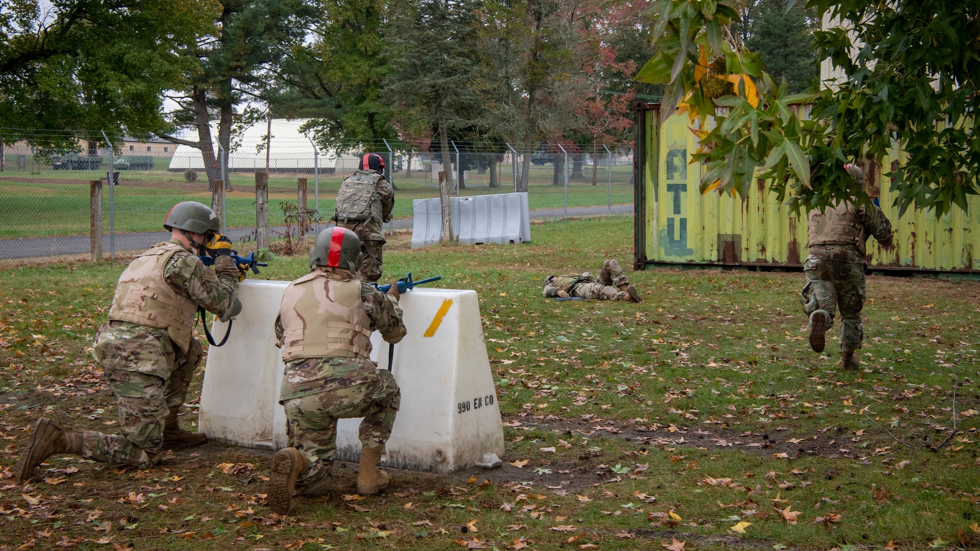 U.S. Airmen from the 514th Air Mobility Wing and the 421st Combat Training Squadron, both at Joint Base McGuire-Dix-Lakehurst, New Jersey, the 171st Air Refueling Wing, Pennsylvania, and the Office of the Surgeon General, Headquarters U.S. Air Force, Virginia, simulate retrieving a fallen comrade while providing tactical cover during the care under fire portion of a Tactical Combat Casualty Care course at the Medical Simulation and Training Center at JB MDL, N.J., October 31, 2021. The course was designed to provide members who are not normally involved in combat environments the skills to survive and care for casualties in the event they are under attack.