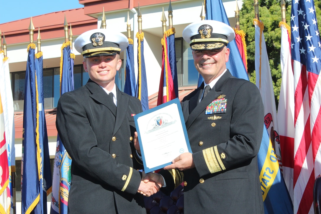 Ensign Austin Roche, left, receives a graduation certificate from Commander of Naval Facilities Engineering Systems Command and 45th Chief of Civil Engineers, Rear Adm. John W. Korka.  Roche was one of 33 U.S. Navy Civil Engineer Corps (CEC) students who completed the 15-week-long CEC Basic Qualification Course at the Naval Civil Engineer Corps Officers School.