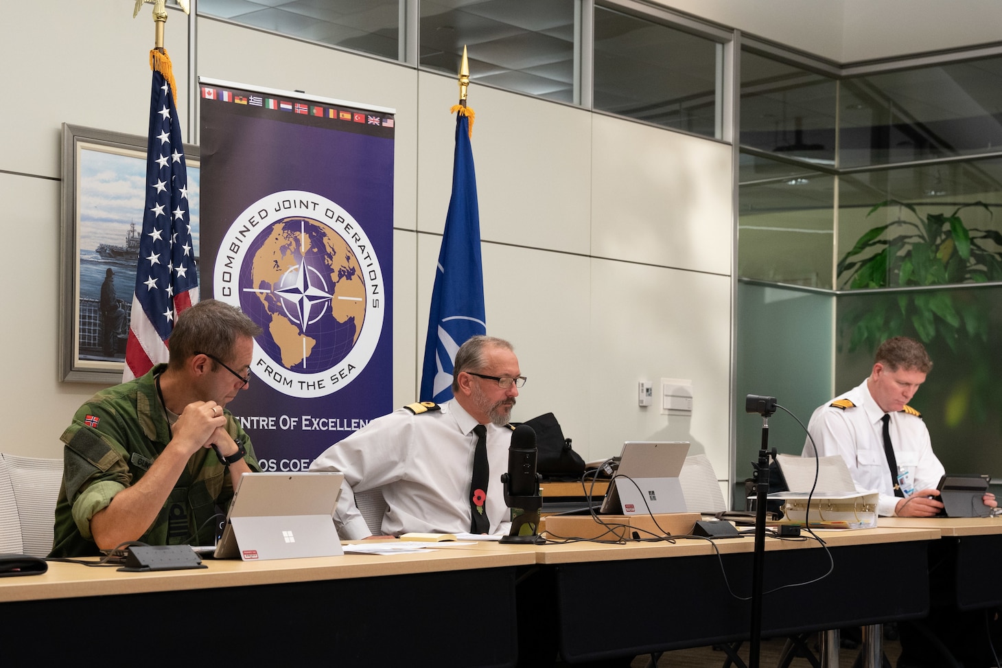 Royal Navy Commodore Tom Guy, deputy director, Combined Joint Operations from the Sea, Centre of Excellence (CJOS COE), center, speaks with NATO counterparts during the 6th annual Maritime Security Regimes Round Table.
