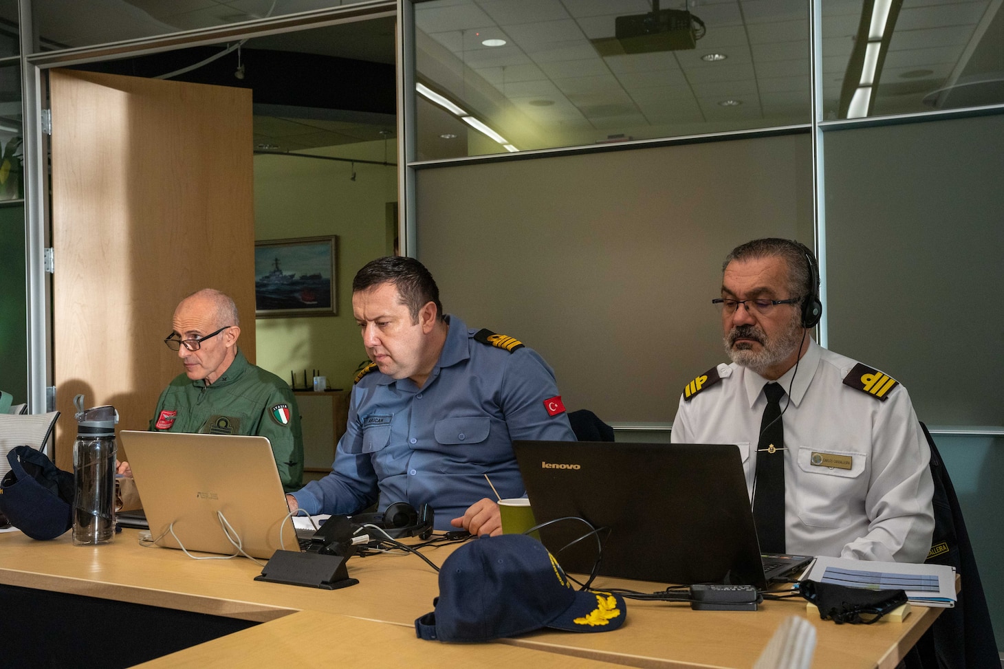 Italian Navy Capt. Giuseppe Catapano, left, Turkish Navy Cmdr. Emir Arican, center, and Spanish Navy Cmdr. Carlos Carballeira, right, listen to welcoming remarks from Vice Adm. Daniel Dwyer, director, Combined Joint Operations from the Sea, Centre of Excellence (CJOS COE), during the 6th annual Maritime Security Regimes Round Table.