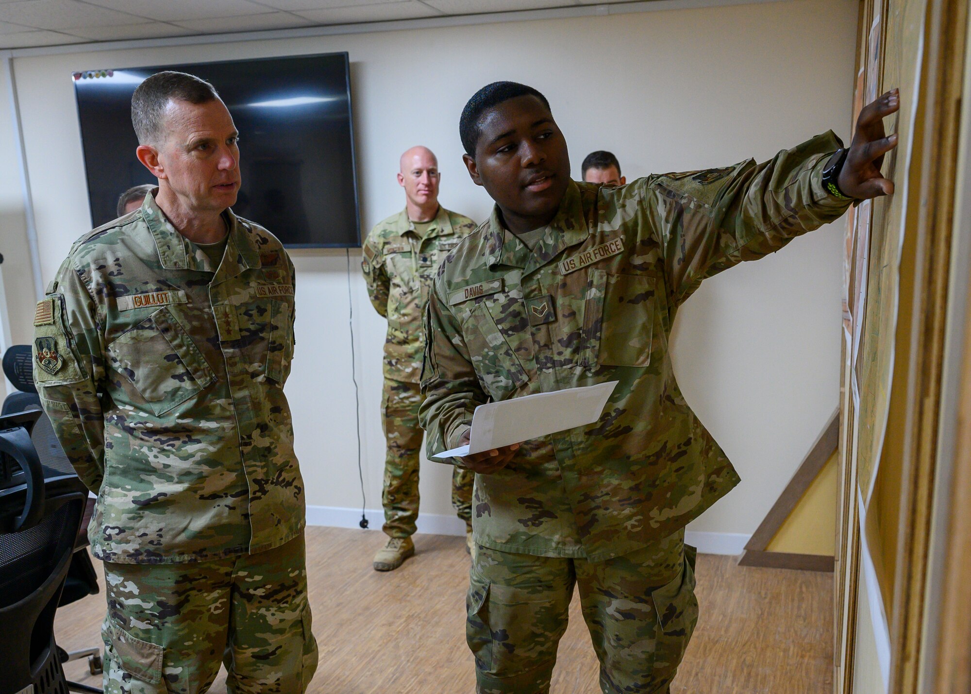 U.S. Air Force Senior Airman Kevon Davis, 378th Expeditionary Operations Group airfield management shift leader, shares information about the progress of airfield projects with U.S. Air Force Lt. Gen. Greg Guillot, 9th Air Force (Air Forces Central) commander, during his visit to Prince Sultan Air Base, Kingdom of Saudi Arabia, Oct. 31, 2021. Guillot visited several units across PSAB, meeting with various personnel to learn about recent innovation, diversity and expansion efforts on base. (U.S. Air Force photo by Senior Airman Samuel Earick)