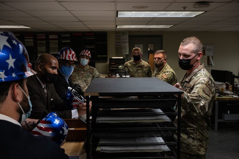 Master Sgt. Joshua Wills, right, 436th Maintenance Squadron Isochronal Maintenance Dock production supervisor, explains ISO dock work processes to the T-Mobile customer discovery team on Dover Air Force Base, Delaware, Oct. 20, 2021. The T-Mobile team met with Dover AFB Airmen to discuss new innovative ways to enhance mission effectiveness and accelerate change in meaningful ways. (U.S. Air Force photo by Senior Airman Marco A. Gomez)