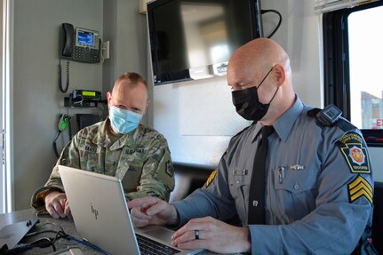 Maj. Victor Yartz, left, Pennsylvania National Guard, and Sgt. Craig Polen, Pennsylvania State Police Bureau of Communications Information Services, work together at the FEMA Region 3-facilitated Fall Regional Emergency Communications Coordination Working Group at Fort Indiantown Gap, Pennsylvania, on Nov. 3, 2021. Pennsylvania State Police set-up their mobile command center at the event.