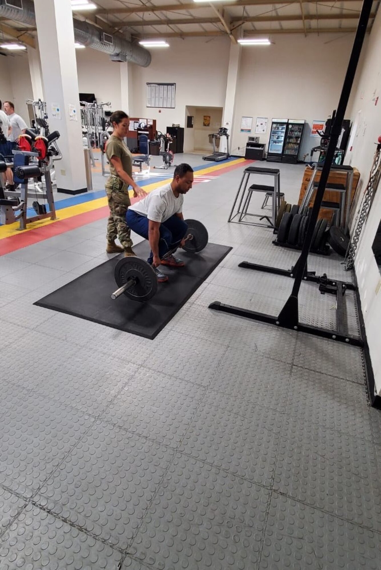 A photo of an Airman being instructed on how to lift properly.