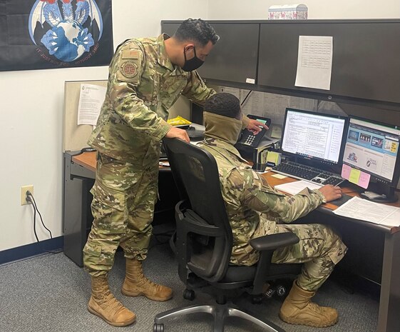 Photo shows two people working at computer