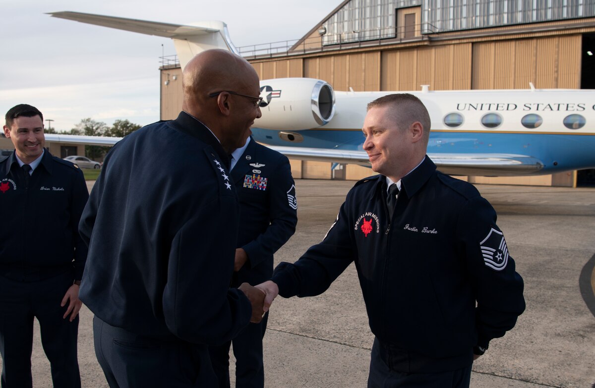Air Force Chief of Staff Gen. CQ Brown, Jr., presents his coin to U.S. Air Force Master Sgt. Justin Burke, a 99th Airlift Squadron communications system operator, at the conclusion of an aircraft delivery ceremony at Joint Base Andrews, Md. Nov. 3, 2021. Burke and an aircrew of 99th Airlift Squadron airmen assisted Brown with flying a new C-37B Gulfstream 550 aircraft, tail #1941, that was dedicated to the founding of the Tuskegee Airmen. (U.S. Air Force photo by Tech. Sgt. Kentavist P. Brackin)