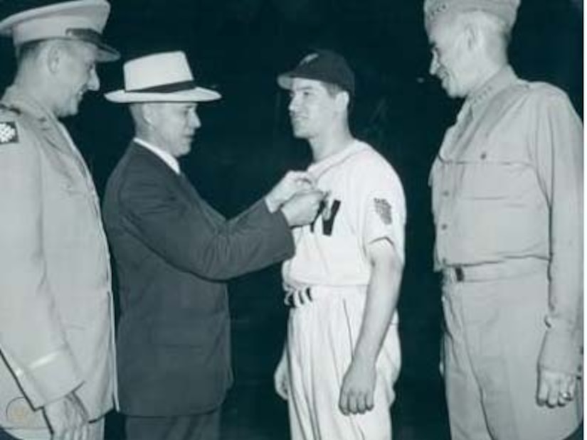 A baseball player gets a medal.