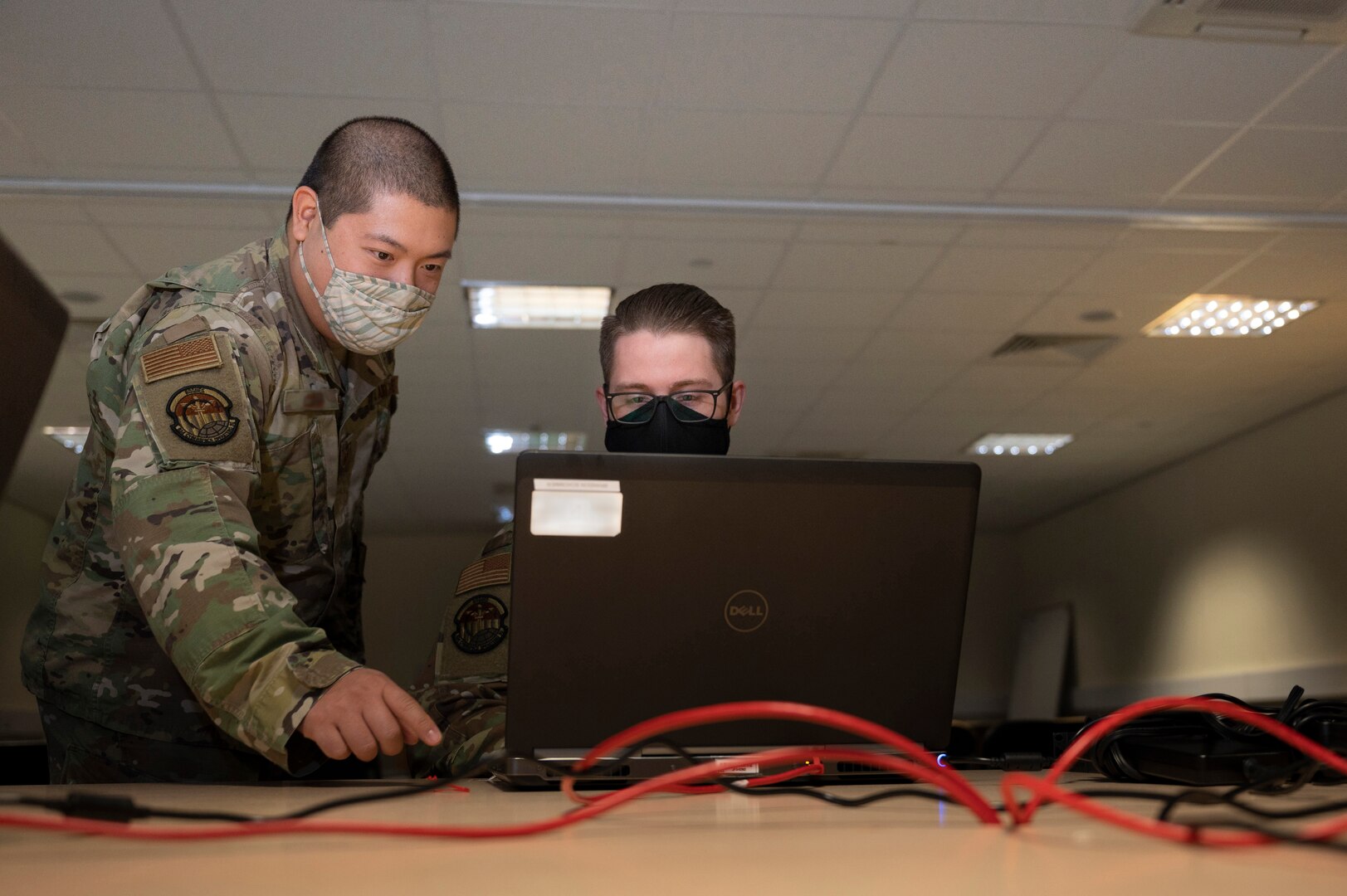 A defensive cyber host noncommissioned officer assigned to the 800th Cyber Protection Team, Joint Force Headquarters Cyber-Air Force, left, assists a defensive cyber host operator while he performs a hunt analysis at RAF Fairford, United Kingdom, Oct. 8, 2021. Cyber defense requires host operators to review security threats to detect adversarial aggression against Air Force systems, such as the B-1B Lancer currently deployed in support of Bomber Task Force Europe. (U.S. Air Force photo by Senior Airman Colin Hollowell)