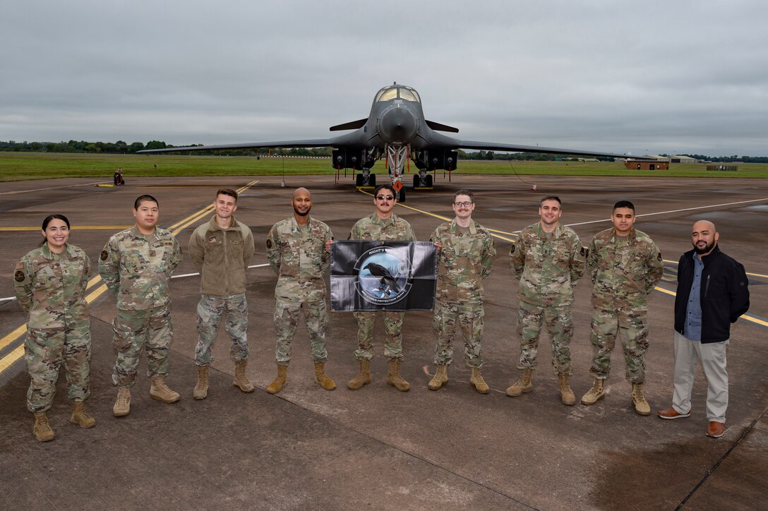 Defensive cyber network and host operators assigned to the 800th Cyber Protection Team, pose in front of a 9th Expeditionary Bomb Squadron B-1B Lancer, at RAF Fairford, United Kingdom, Oct. 8, 2021. The 800th CPT, Joint Force Headquarters Cyber- Air Force, is supporting the 9th Expeditionary Bomb Squadron during a Bomber Task Force Europe deployment by hunting and hardening systems on the B-1 to ensure components were free of any adversary activity. (U.S. Air Force photo by Senior Airman Colin Hollowell)