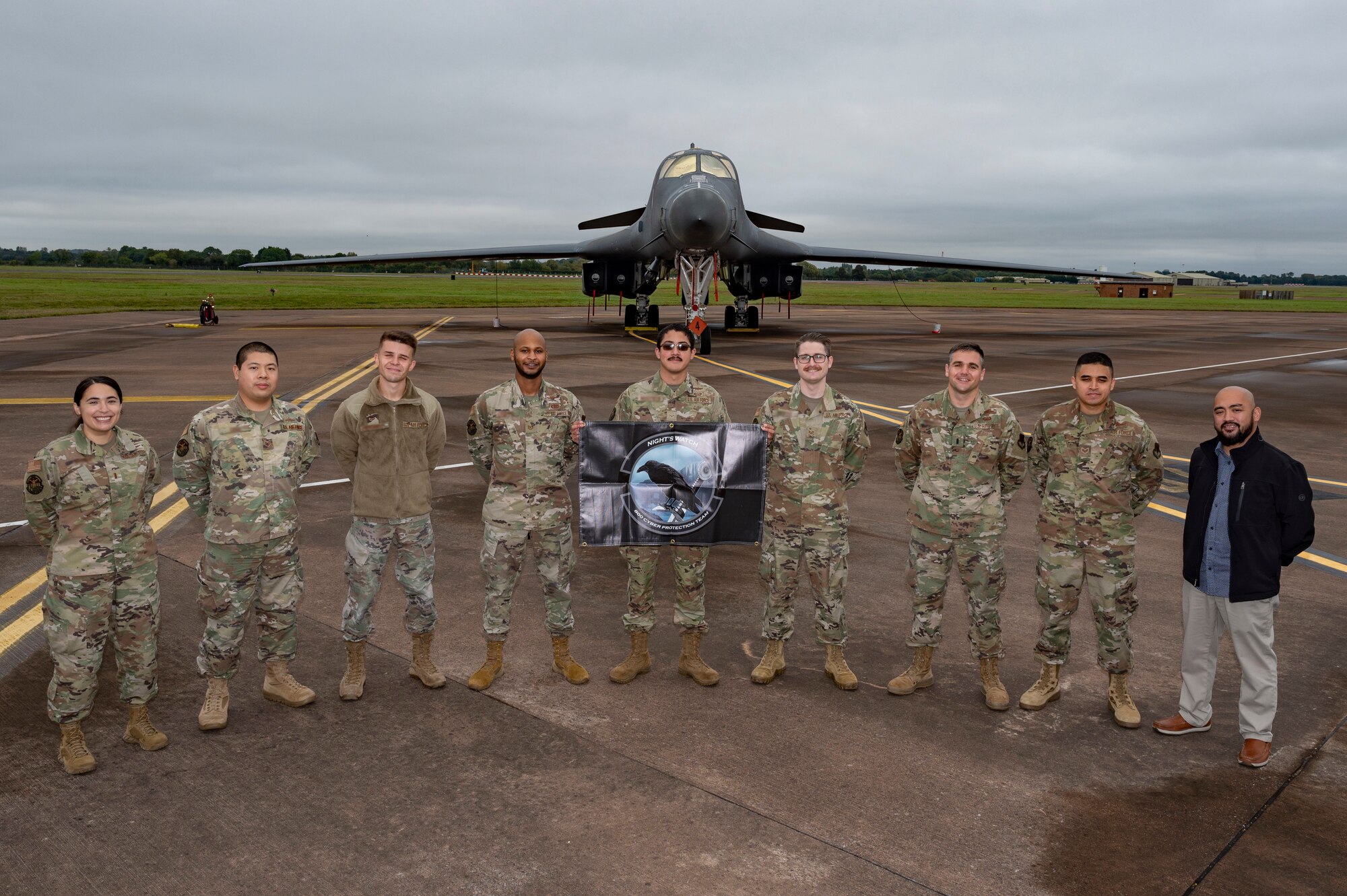 Defensive cyber network and host operators assigned to the 800th Cyber Protection Team, pose in front of a 9th Expeditionary Bomb Squadron B-1B Lancer, at RAF Fairford, United Kingdom, Oct. 8, 2021. The 800th CPT, Joint Force Headquarters Cyber- Air Force, is supporting the 9th Expeditionary Bomb Squadron during a Bomber Task Force Europe deployment by hunting and hardening systems on the B-1 to ensure components were free of any adversary activity. (U.S. Air Force photo by Senior Airman Colin Hollowell)