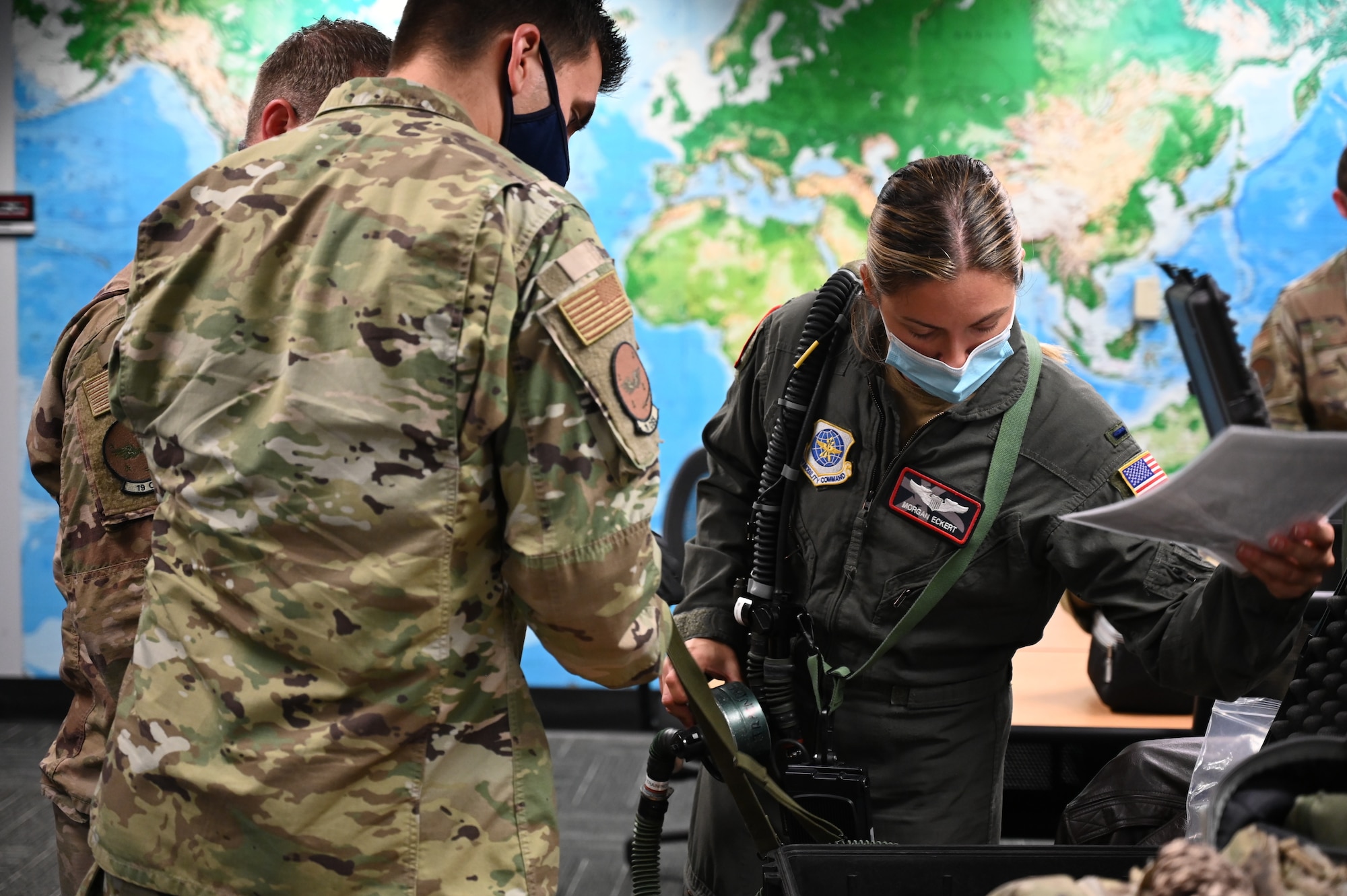 Pilots prepare gear in a room before heading to a C-130J.