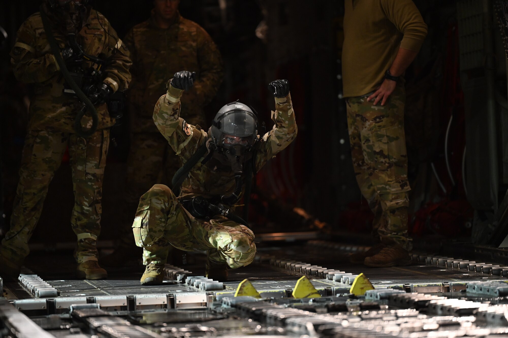 A loadmaster directs a pallet off a C-130J.