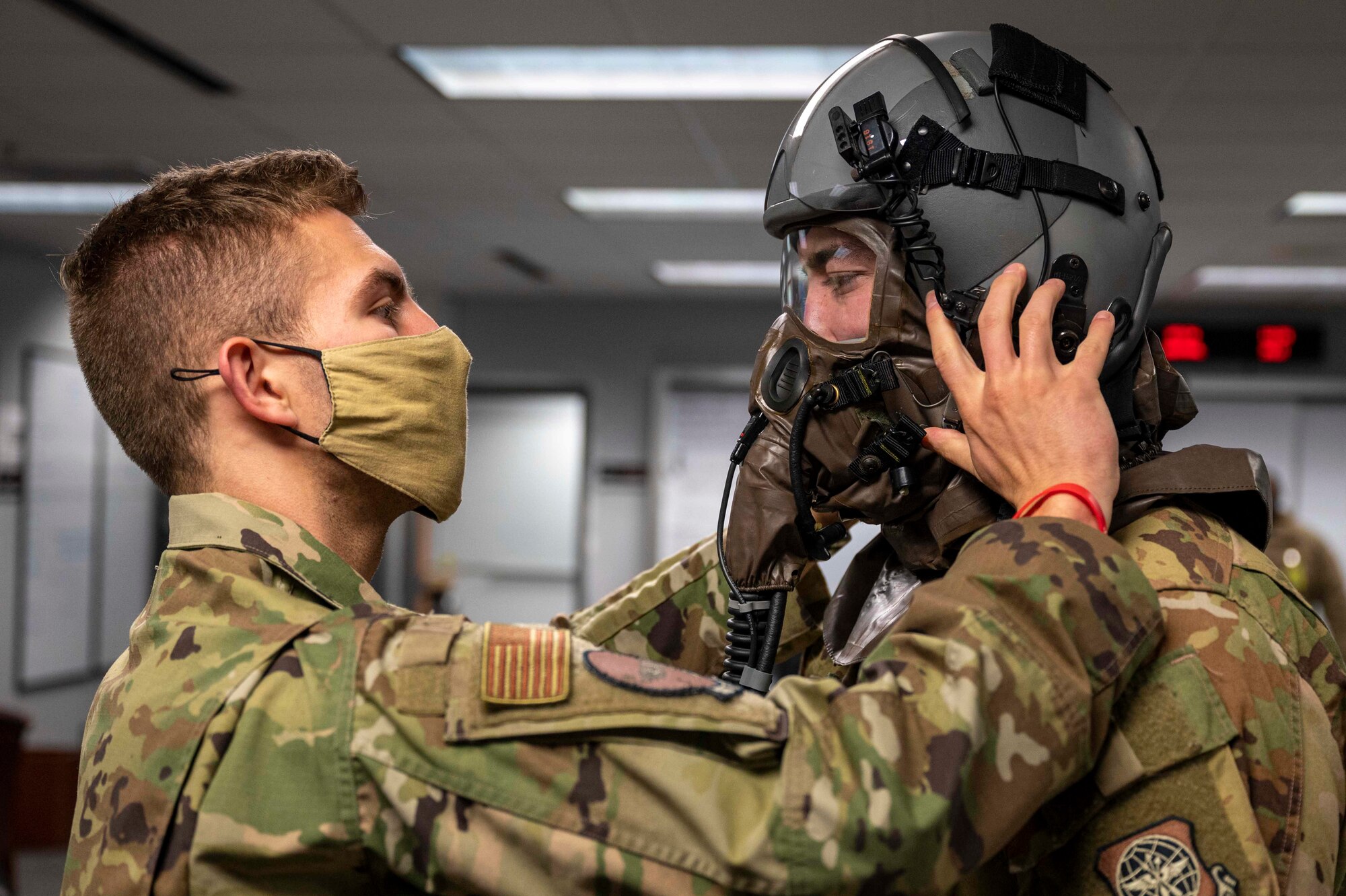 A member from AFE assists a loadmaster in donning AERPS gear.