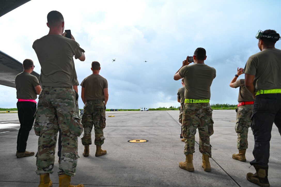 Photo of Airmen photographing an aircraft in flight