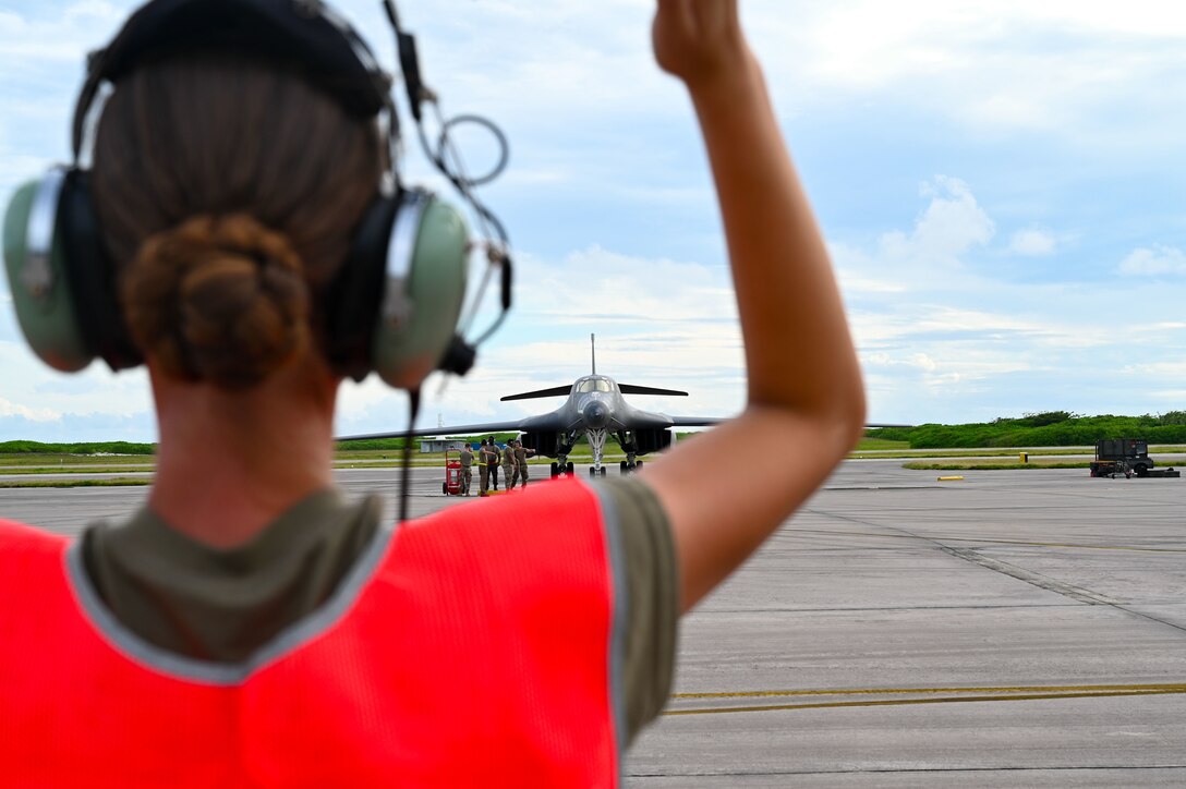 Photo of an Airman marshaling an aircraft