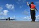 Photo of crew chief marshaling aircraft