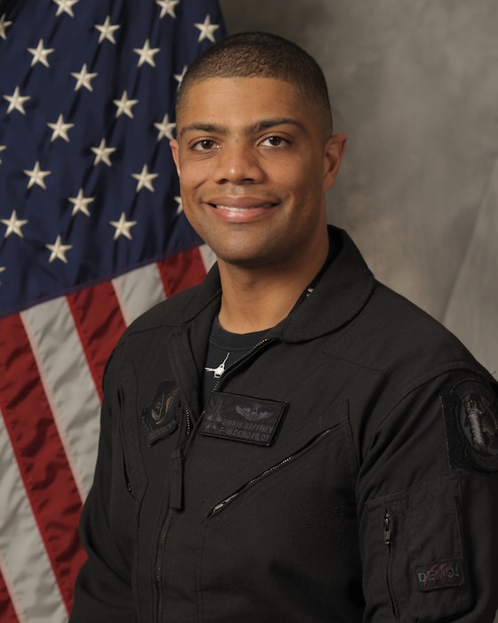 A portrait photo of a man in a black flight suit