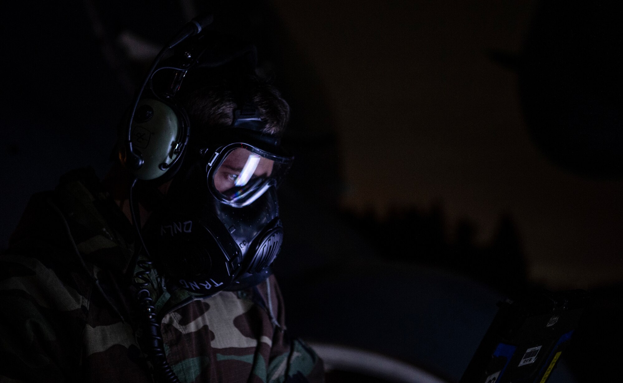 U.S. Air Force Senior Airman James Reed, 62nd Aircraft Maintenance Squadron maintainer,  reviews guidance for refueling a C-17 Globemaster III while in full Mission Oriented Protective Posture (MOPP) gear during Exercise Rainier War 21B at Joint Base Lewis-McChord, Washington, Nov. 3, 2021. Rainier War is a semi-annual, large readiness exercise led by 62nd Airlift Wing, designed to train aircrews under realistic scenarios that support a full spectrum readiness operations against modern threats and replicate today’s contingency operations. (U.S. Air Force photo by Staff Sgt. Tryphena Mayhugh)