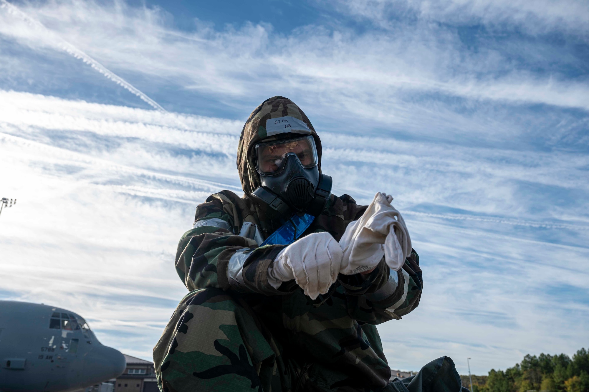 An airman puts on MOPP gear on the flightline.