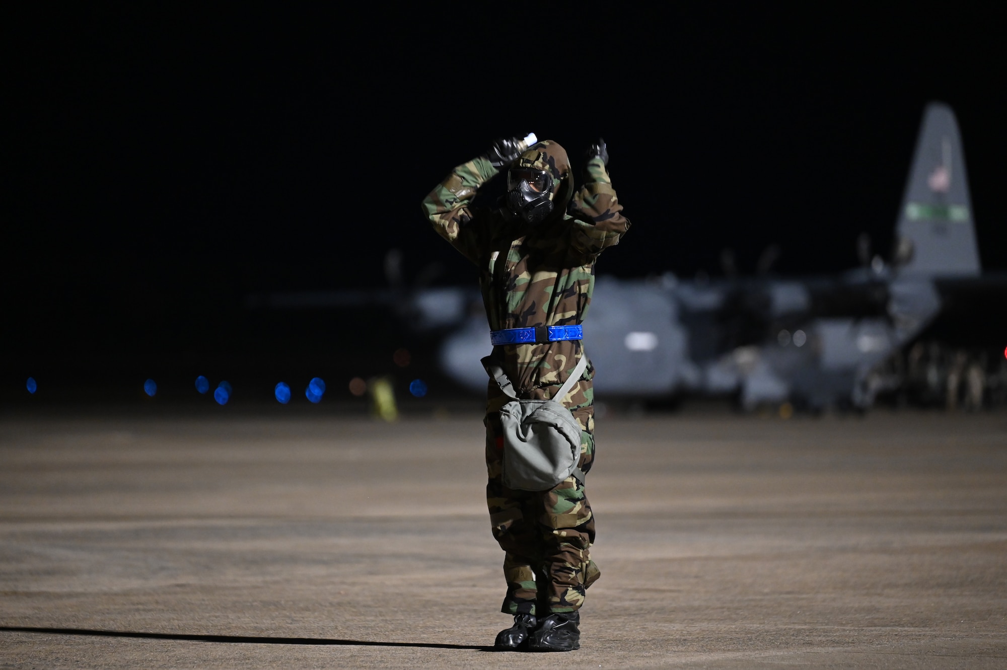 An LRS Airman directs a cargo loader away from a C-130J.