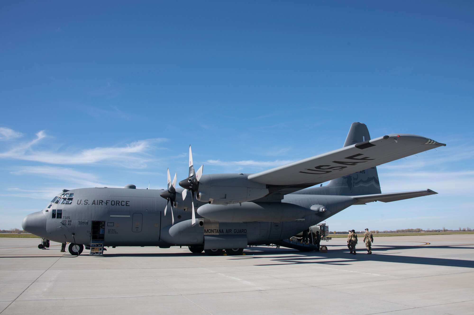 A C-130 Hercules sits stationary on the flight line