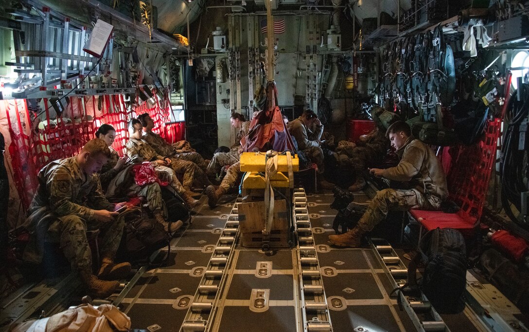 Airmen sit inside a C-130 Hercules aircraft
