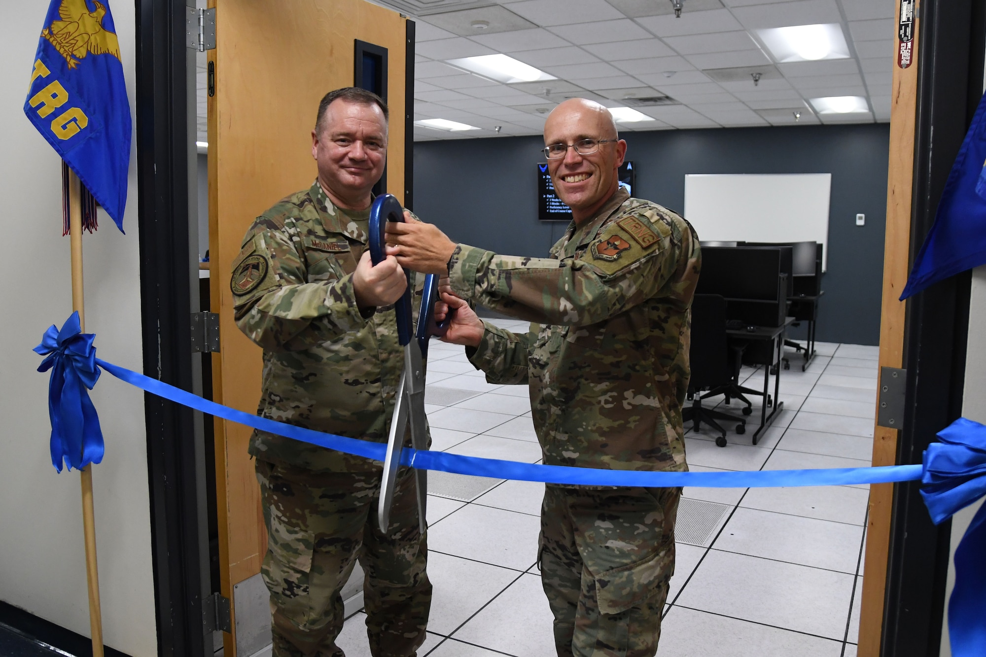 U.S. Air Force Brig. Gen. Charles McDaniel, Director of Weather, Deputy Chief of Staff for Operations, Headquarters U.S. Air Force, the Pentagon, Arlington, Virginia, and Col. Chance Geray, 81st Training Group commander, pose for a photo during the Space Weather Support Course ribbon cutting ceremony inside the Weather Training Complex at Keesler Air Force Base, Mississippi, Nov. 3, 2021. The course will apply knowledge of the effects of the natural environment on space systems and also space weather effects on terrestrial systems in support of multi-domain operations. (U.S. Air Force photo by Kemberly Groue)