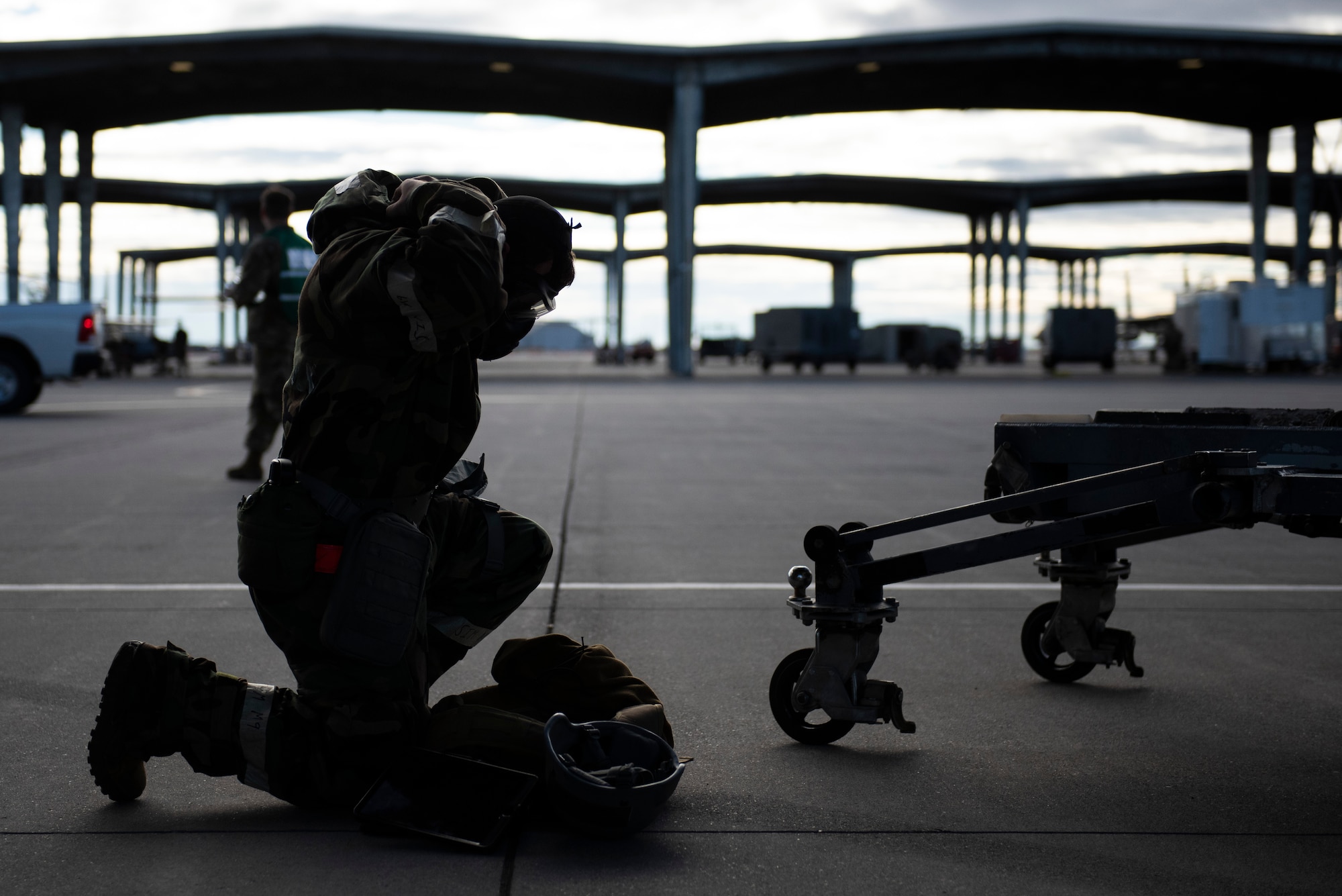 A U.S. Air Force Airman puts on his chemical gear during a simulated chemical attack on Mountain Home Air Force Base, Idaho, Oct. 28, 2021. Mission generation during this exercise is essential to see how we would continue to operate in a contested chemical environment.