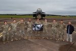 Defensive cyber network and host operators assigned to the 800th Cyber Protection Team, pose in front of a 9th Expeditionary Bomb Squadron B-1B Lancer, at RAF Fairford, United Kingdom, Oct. 8, 2021. The 800th CPT, Joint Force Headquarters Cyber- Air Force, is supporting the 9th Expeditionary Bomb Squadron during a Bomber Task Force Europe deployment by hunting and hardening systems on the B-1 to ensure components were free of any adversary activity. (U.S. Air Force photo by Senior Airman Colin Hollowell)