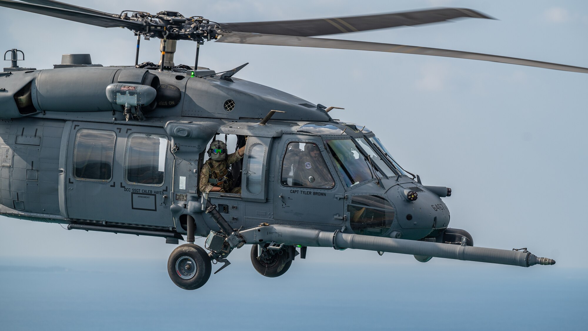 A helicopter flies over the Pacific Ocean.