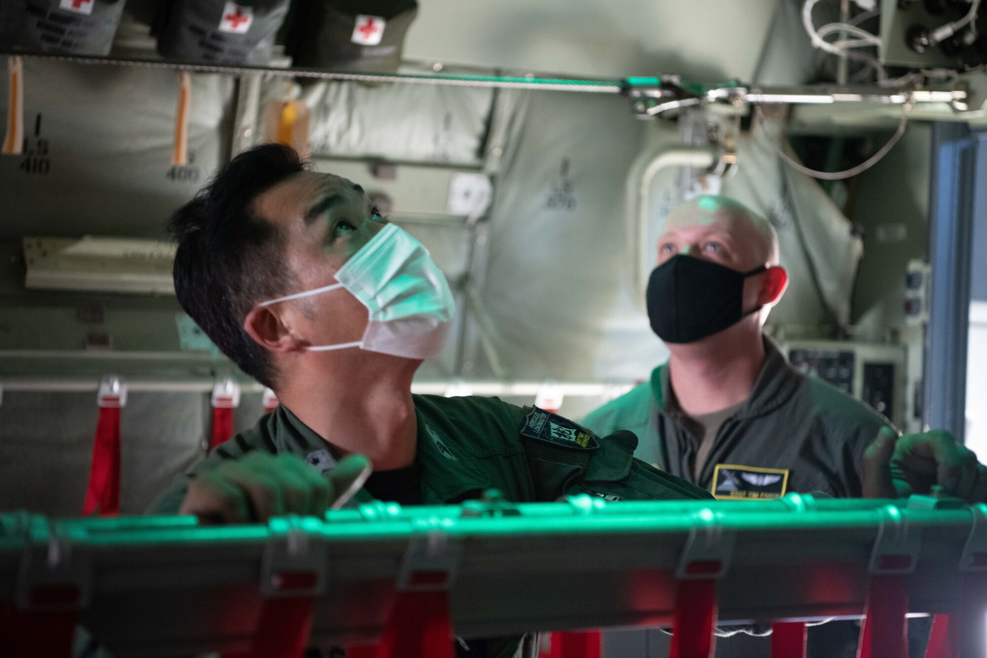 Koku-Jieitai (Japan Air Self-Defense Force) Master Sgt. Tatsuhiko Kurimoto, 401st Tactical Airlift Squadron loadmaster, left, and U.S. Air Force Staff Sgt. Timothy Foote, 36th Airlift Squadron C-130J loadmaster, observe a sensor aboard a C-130J Super Hercules