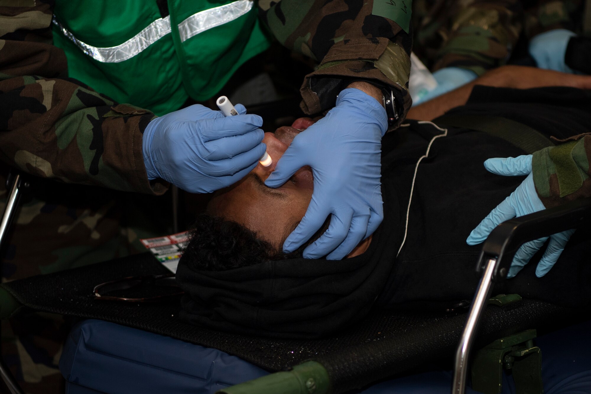 U.S. Air Force 52nd Medical Group Airmen evaluate the eyes of a mock patient during exercise Sabre Storm, Nov. 3, 2021, on Spangdahlem Air Base, Germany. This exercise gave the Wing Inspection Team an opportunity to evaluate the Installation Medical All Hazards Response team on their response techniques. (U.S. Air Force photo by Staff Sgt. Melody W. Howley)