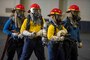 Sailors take part in a fire drill in the hangar bay during a fast cruise aboard the aircraft carrier USS Nimitz (CVN 68)