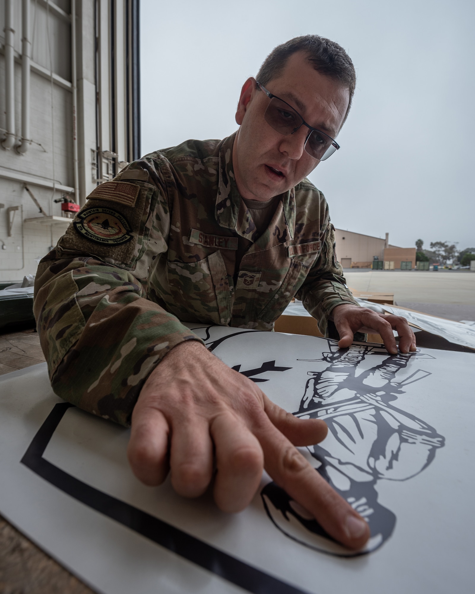 Master Sgt. Lee Stanley, aircraft structural repair shop chief for the 123rd Maintenance Group, prepares an Air National Guard emblem decal to be applied to the tail of one of the Kentucky Air National Guard’s newly acquired C-130J Super Hercules aircraft at Channel Islands Air Guard Station in Port Hueneme, Calif., Nov. 4, 2021. The aircraft will be replacing the C-130H Hercules, which has been in service to the Kentucky Air National Guard since 1992. (U.S. Air National Guard photo by Tech. Sgt. Joshua Horton)