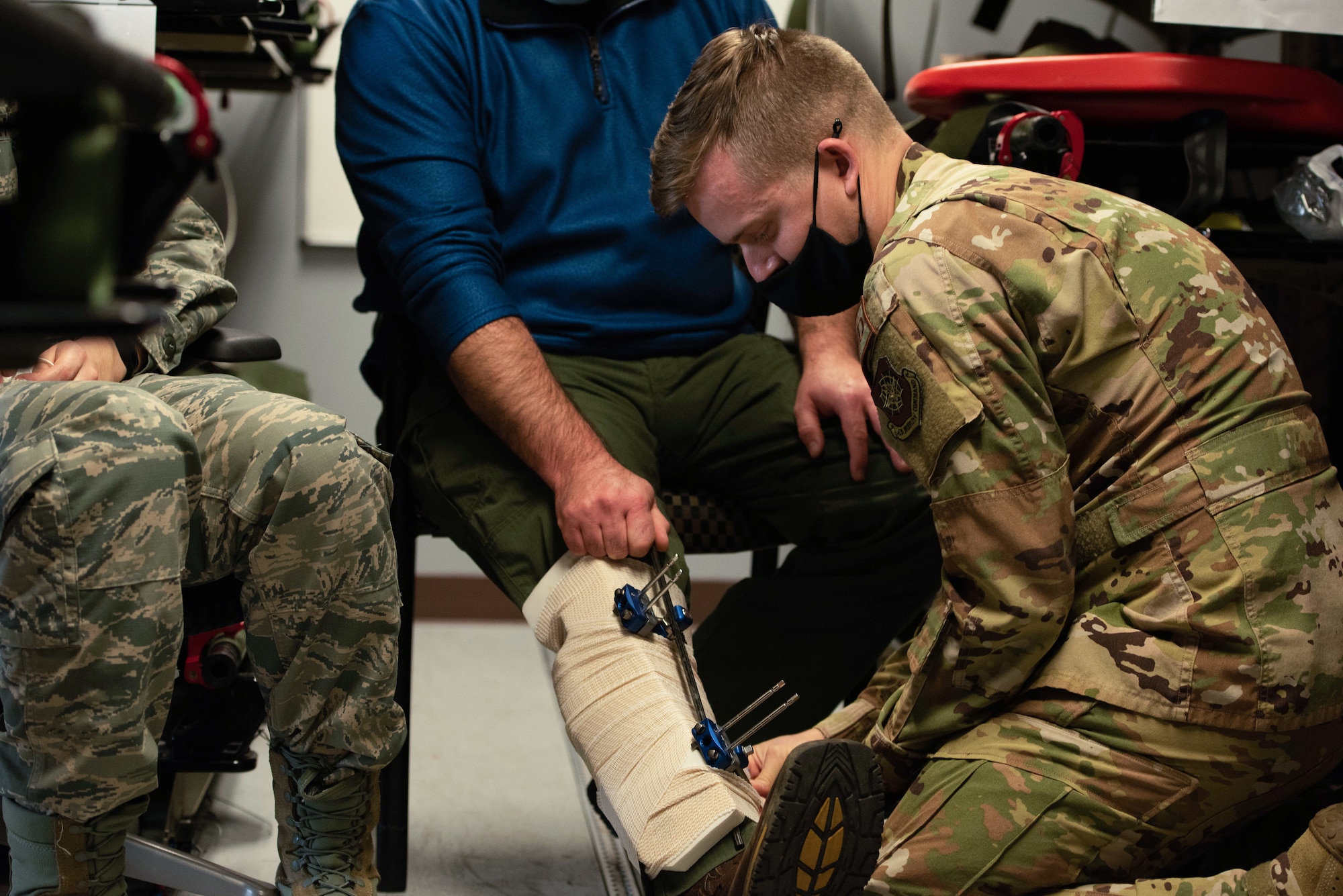 U.S. Air Force Capt. John Ininns, 375th Aeromedical Evacuation Squadron clinical nurse, wraps badges around a simulated patient’s leg on Scott AFB, Illinois, Nov. 3, 2021. This was part of a training exercise to simulate serious injuries to prepare Airmen from the 375th AES for real-world evacuation scenarios. (U.S. Air Force photo by Airman 1st Class Mark Sulaica)
