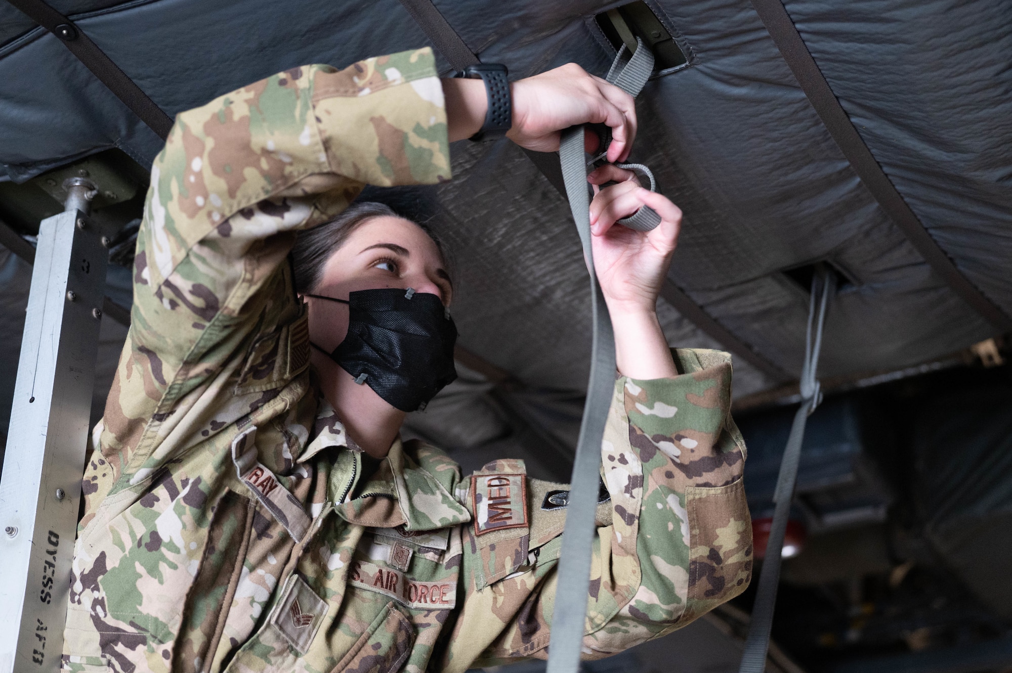 U.S. Air Force Senior Airman Chelsey Ray, 375th Aeromedical Evacuation Squadron aeromedical technician, secures straps during a training exercise on Scott Air Force Base, Illinois, Nov. 3, 2021. Members of the 375th AES interact with loadmasters in real-world scenarios to prepare the aircraft for extraction of patients. (U.S. Air Force photo by Airman 1st Class Stephanie Henry)