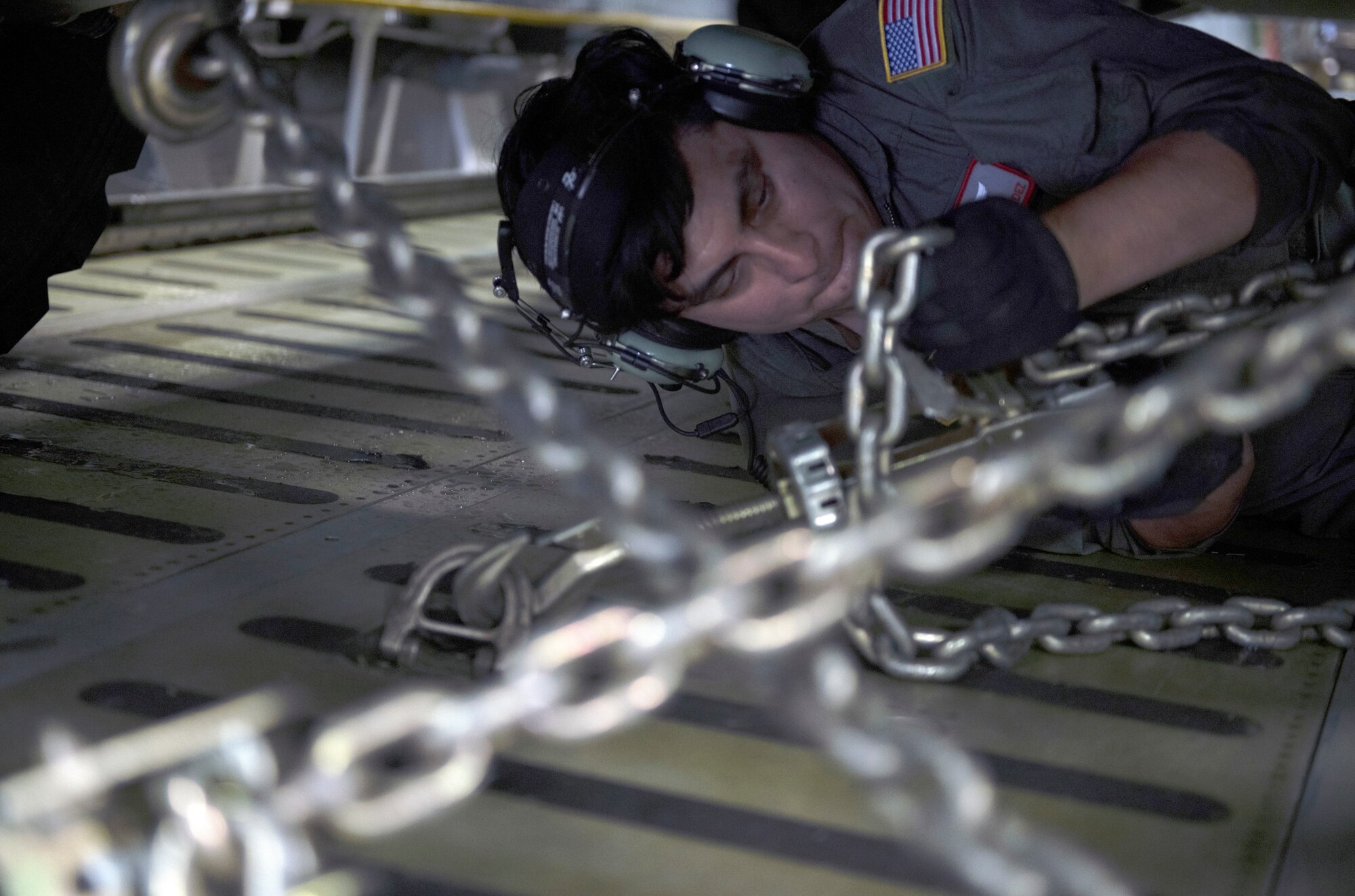 A Airman secures a joint light tactical vehicle inside a C-5M Super Galaxy