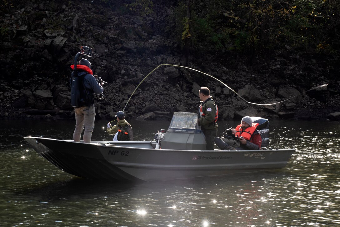 Park Ranger Gary Bruce maneuvers a Corps of Engineers boat into position Nov. 2, 2021 to allow an Open Jaw Productions film crew to obtain imagery of Phillip Sliger fly fishing in the Caney Fork River below Center Hill Dam in Lancaster, Tennessee. Trout fishing is a popular recreation activity in the tailwater at the project operated and maintained by the U.S. Army Corps of Engineers Nashville District. The imagery is being used for a USACE National Inventory of Dams video production. (USACE Photo by Lee Roberts)
