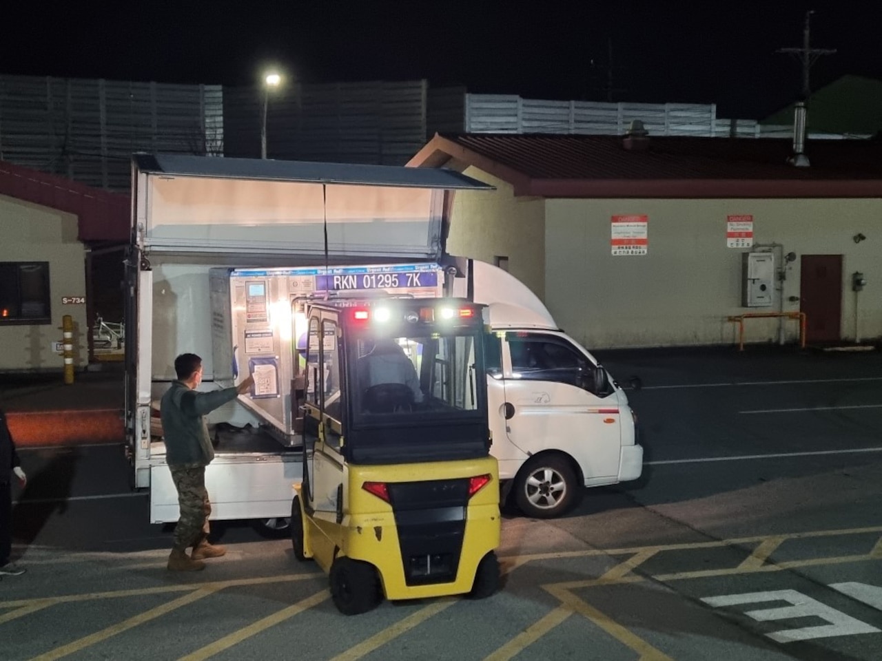 A small forklift is used to unload boxes from a van.