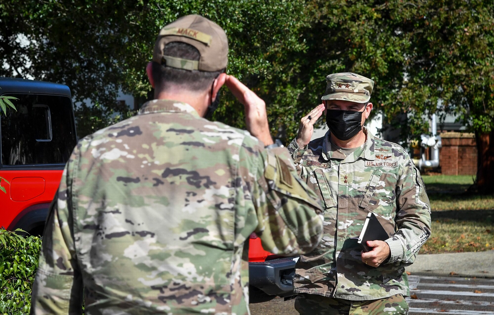 Two Air Force members salute each other.