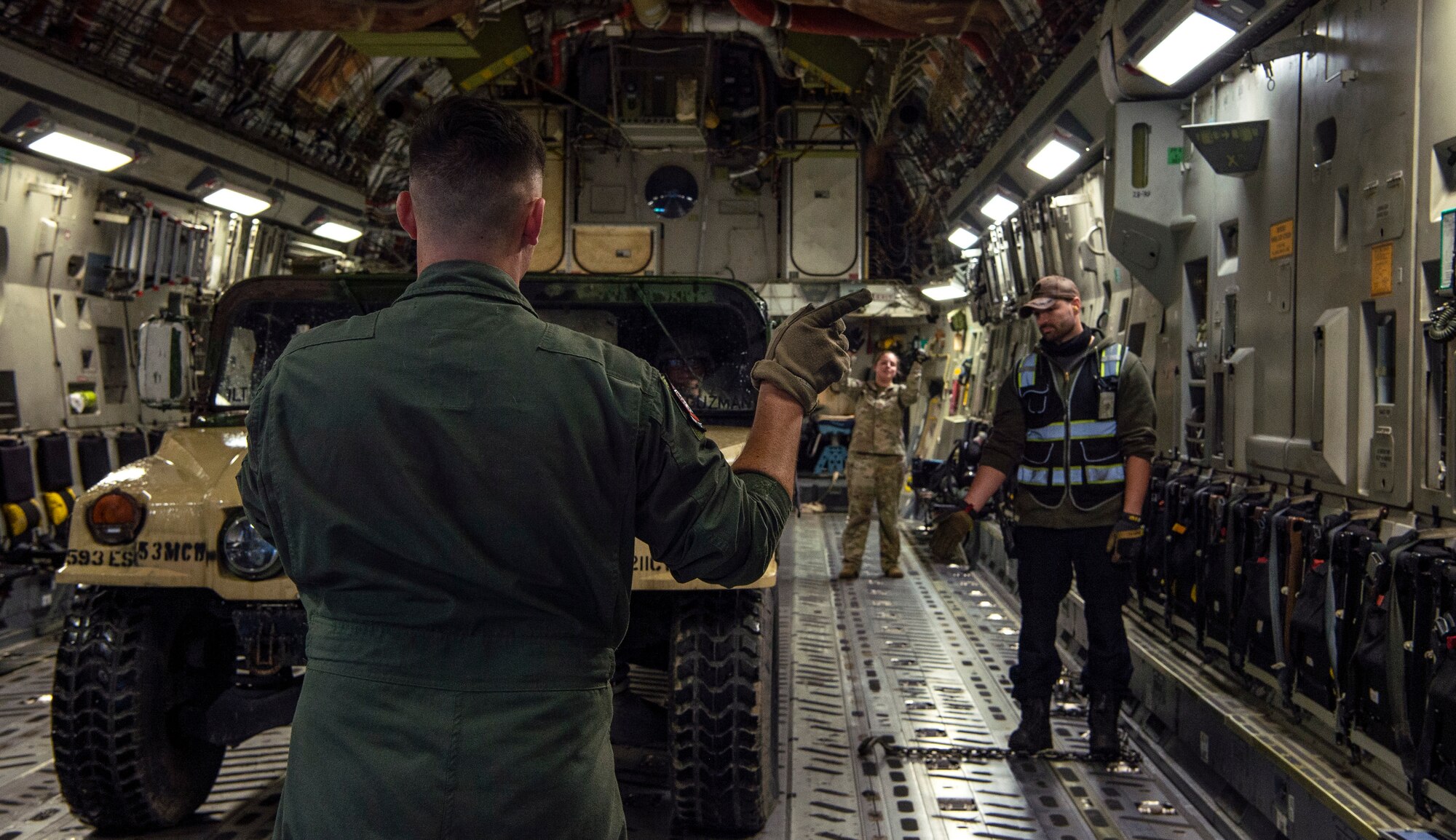 U.S. Air Force Senior Airman Peter Siviglia, 4th Airlift Squadron loadmaster, marshals a U.S. Army HUMVEE onto a C-17 Globemaster III during Exercise Rainier War 21B at Joint Base Lewis-McChord, Washington, Nov. 3, 2021. Rainier War is a semi-annual, large readiness exercise led by 62nd Airlift Wing, designed to train aircrews under realistic scenarios that support a full spectrum readiness operations against modern threats and replicate today’s contingency operations. (U.S. Air Force photo by Staff Sgt. Tryphena Mayhugh)