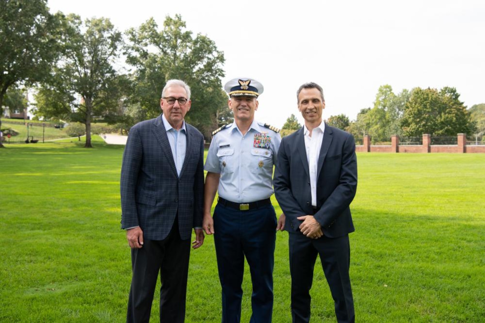 From left, Sal Paolantonio, ESPN reporter, Capt. Rick Wester, Assistant Superintendent of the Coast Guard Academy and James Pitaro, President of ESPN, pose for a group photo on the academy's parade field, Sep. 28, 2021. ESPN was filming with the Coast Guard for their annual Veterans Day special, this year's special is focused on the Coast Guard. (U.S. Coast Guard photo by Petty Officer 3rd Class Matthew Abban)