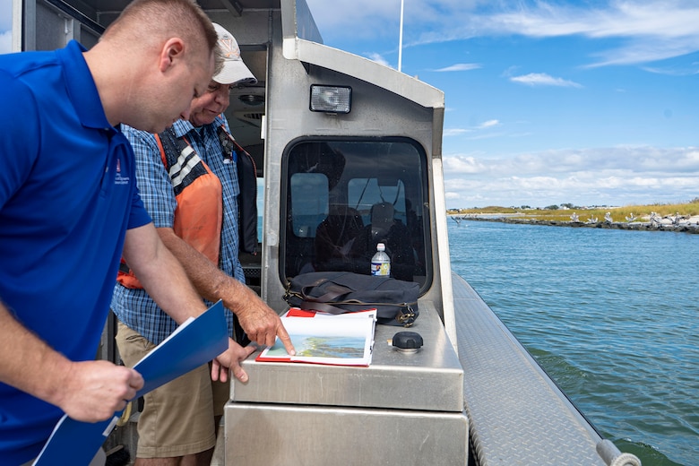 Jason Peters, U.S. Army Corps of Engineers, Baltimore District, Regulatory Senior Project Manager (front), and Scott Hardaway, Coastline Design and Construction, Inc., first mate, navigate shoreline protection structures engineered to protect areas of low-lying marsh and dune habitats during a tour of coastal resiliency projects near Rhodes Point, Smith Island, Somerset County, Md., Oct. 7, 2021. USACE supports an integrated strategy for reducing coastal risks and increasing human and ecosystem community resilience by combining the full array of measures: natural, nature-based, nonstructural, and structural. (U.S. Army photo by Greg Nash)