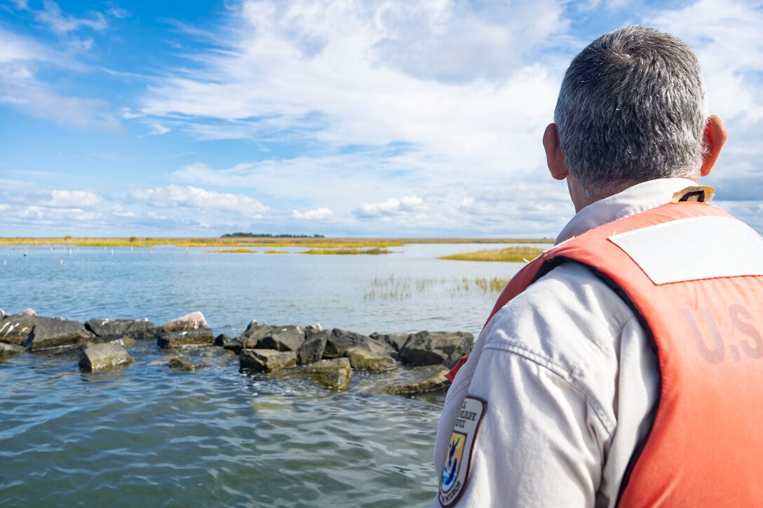 Matt Whitbeck, U.S. Fish and Wildlife Service supervisory biologist, examines shoreline protection improvements during a coastal resiliency project tour at Smith Island near Ewell, Md., Oct. 7, 2021. Recent hurricane events have emphasized the increasing vulnerability of coastal areas to natural disasters through the combination of changing climate, geological processes, and accelerating sea level rise and shoreline erosion. Improving resilience—the ability to anticipate, prepare for, respond to, and adapt to changing conditions and withstand and recover rapidly from disruptions with minimal damage—is a crucial objective of reducing risk. (U.S. Army photo by Greg Nash)