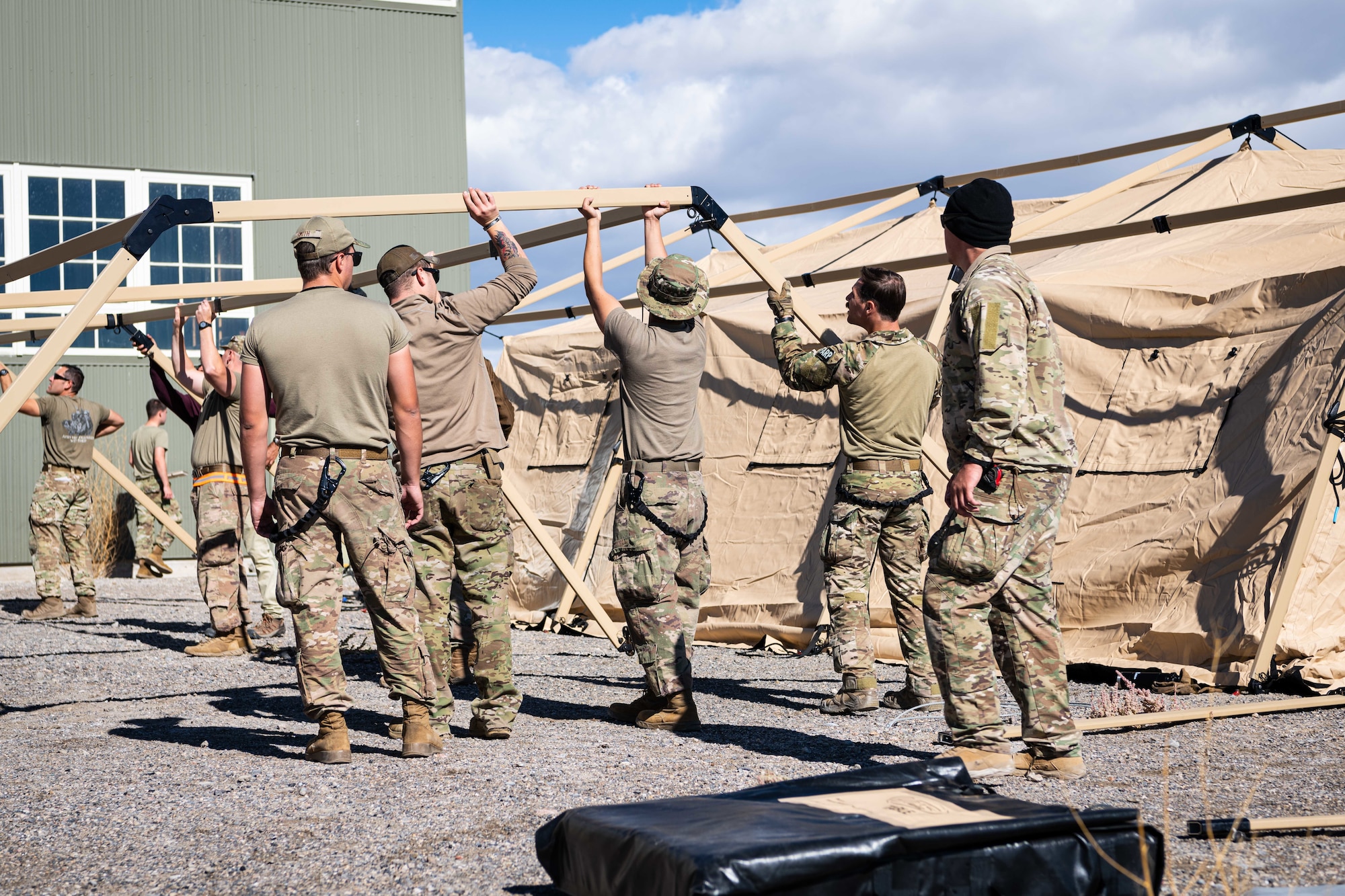 A group of Airmen construct a tent.